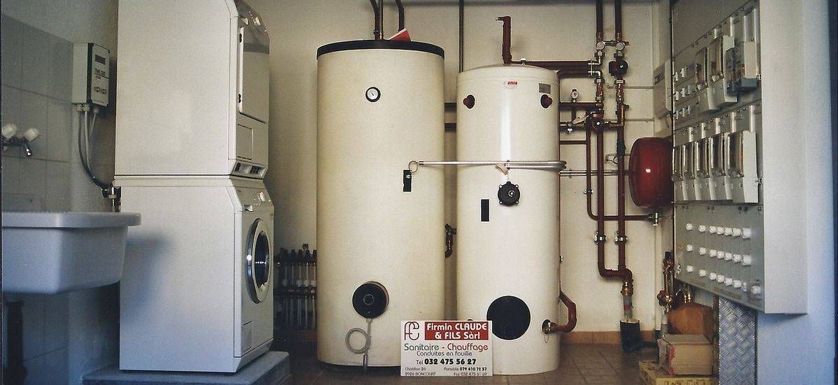 Une buanderie avec laveuse, sécheuse et deux réservoirs d'eau