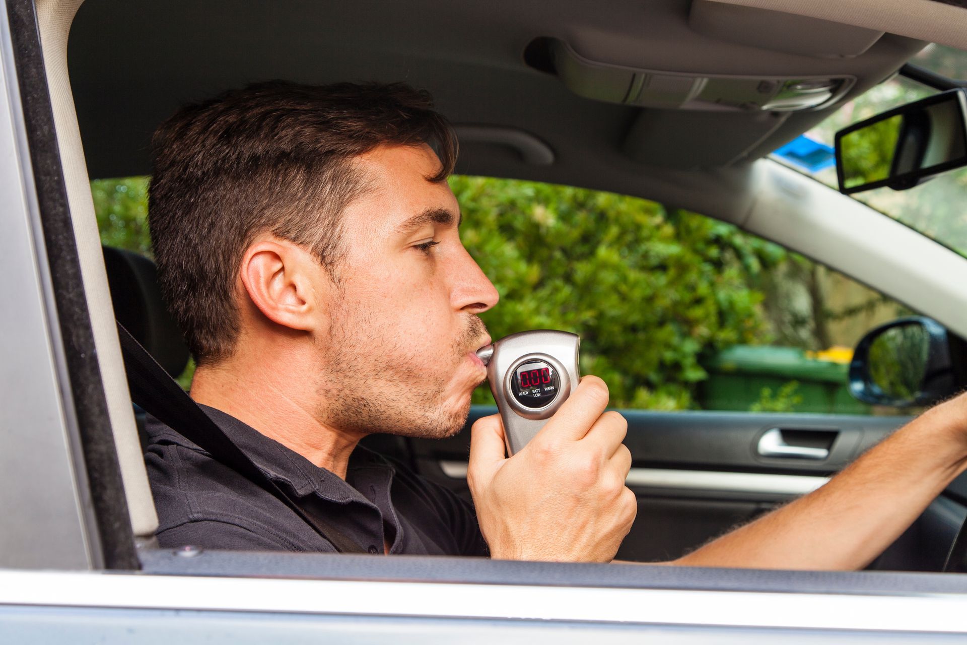 Avant de prendre la voiture, un homme souffle dans l'éthylotest