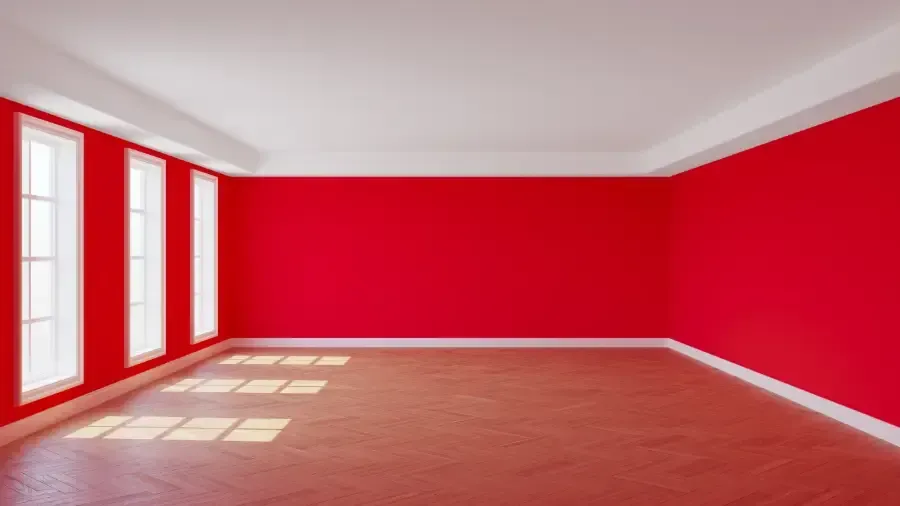 Una habitación vacía con paredes rojas y suelos de madera.