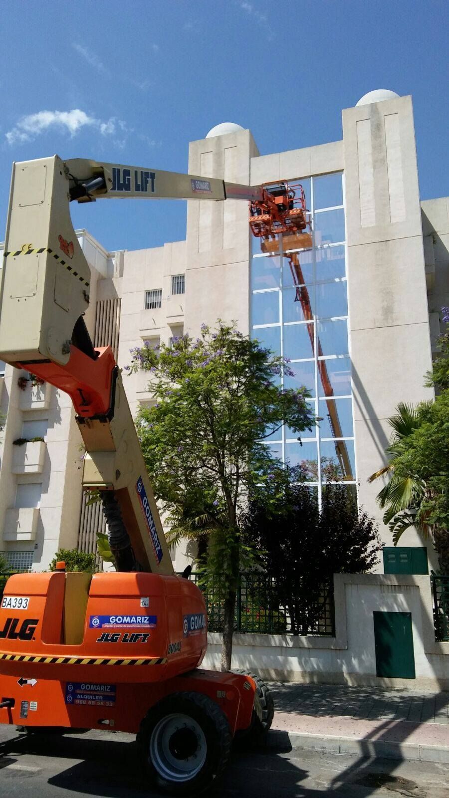 Se está utilizando una grúa para limpiar las ventanas de un edificio.
