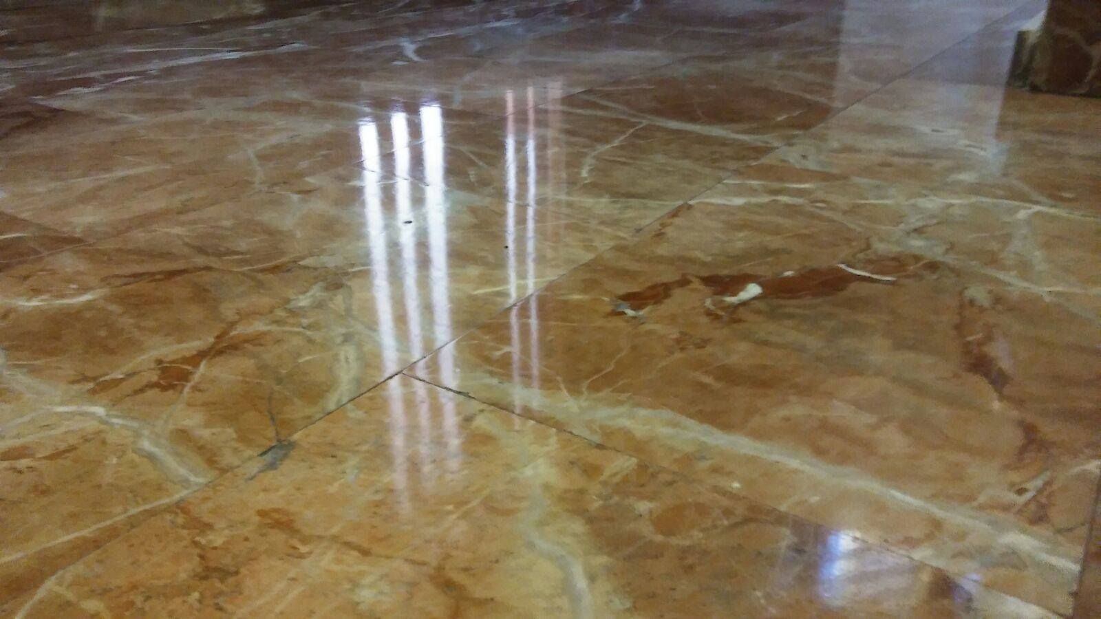 Un primer plano de un suelo de mármol con el reflejo de una luz.