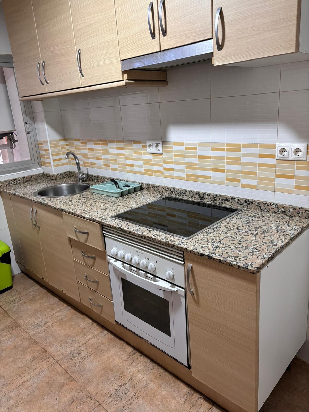 Una cocina con estufa, fregadero y gabinetes.