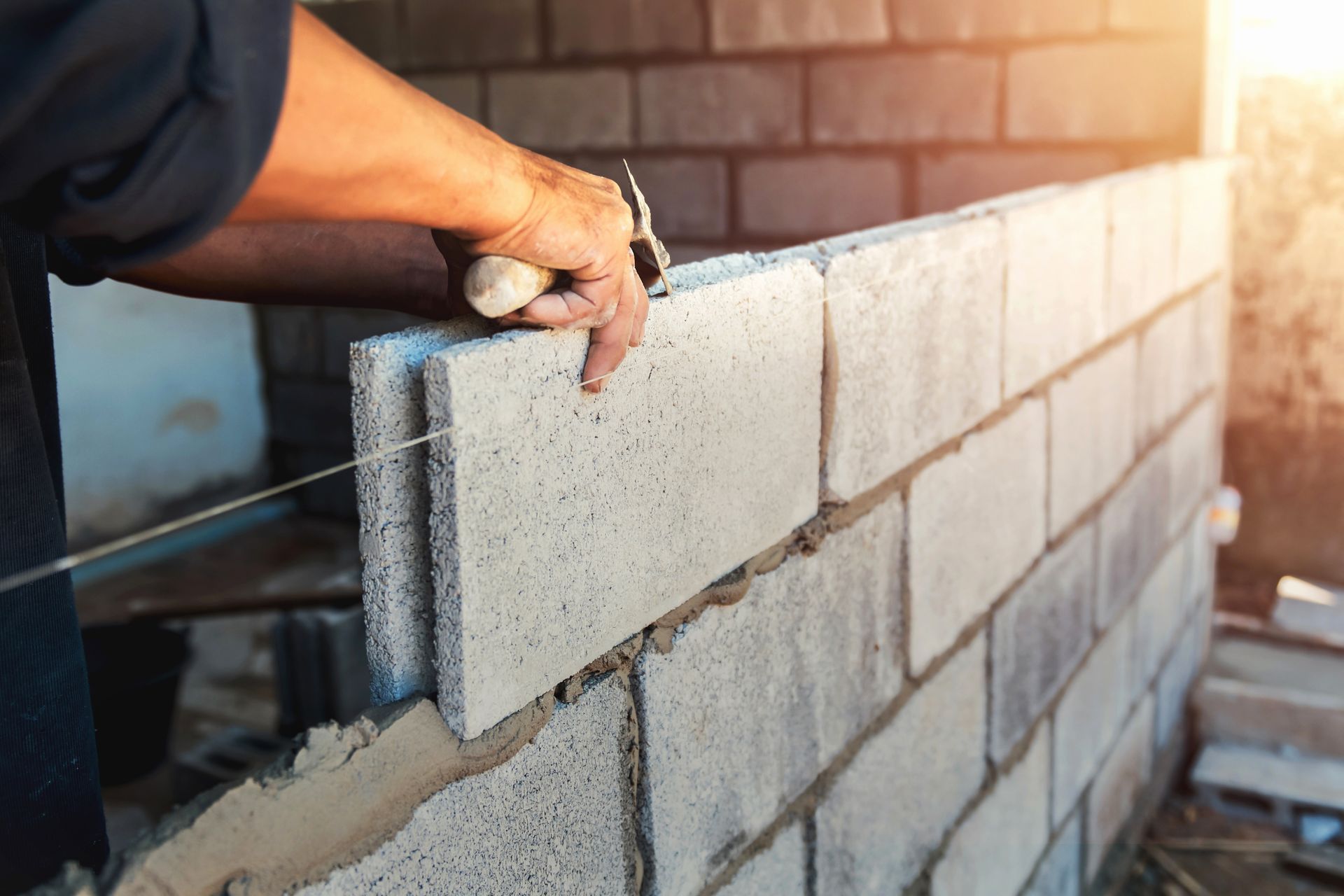 Ouvrier plaçant un bloc de béton dans un mur en construction sur un chantier