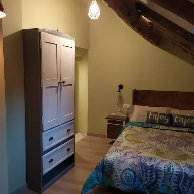 Un dormitorio con una cama y un cartel que dice disfruta