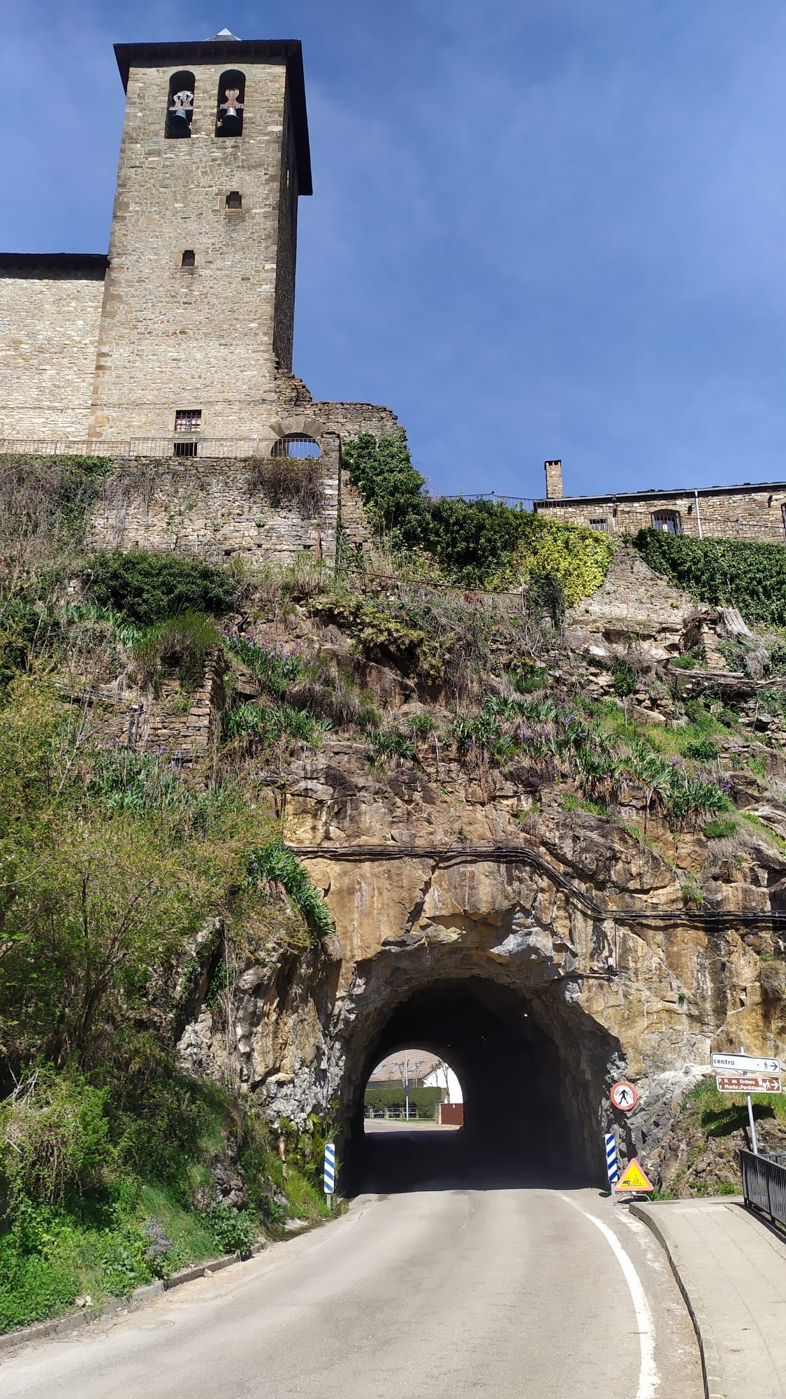 Una carretera que pasa por un túnel con un castillo al fondo.
