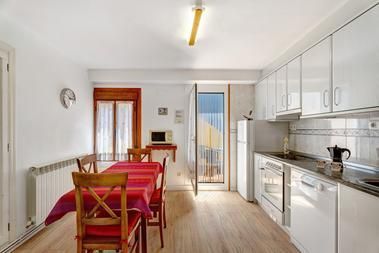 Un comedor con una mesa y sillas y un reloj en la pared.