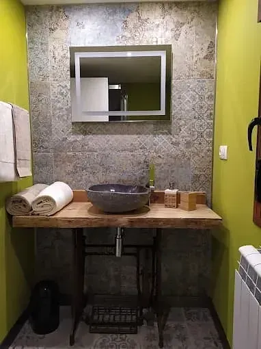 Un baño con lavabo, espejo y toallas en la encimera.