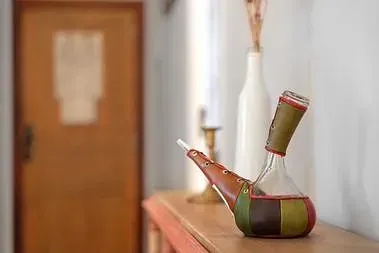 Una botella con una pajita dentro está sobre una mesa de madera.