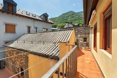 Un balcón con vista a un edificio y a las montañas.