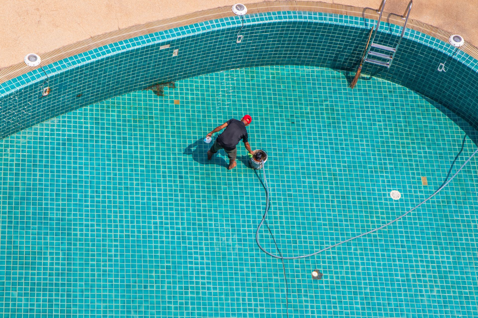 Un homme qui nettoie une piscine.