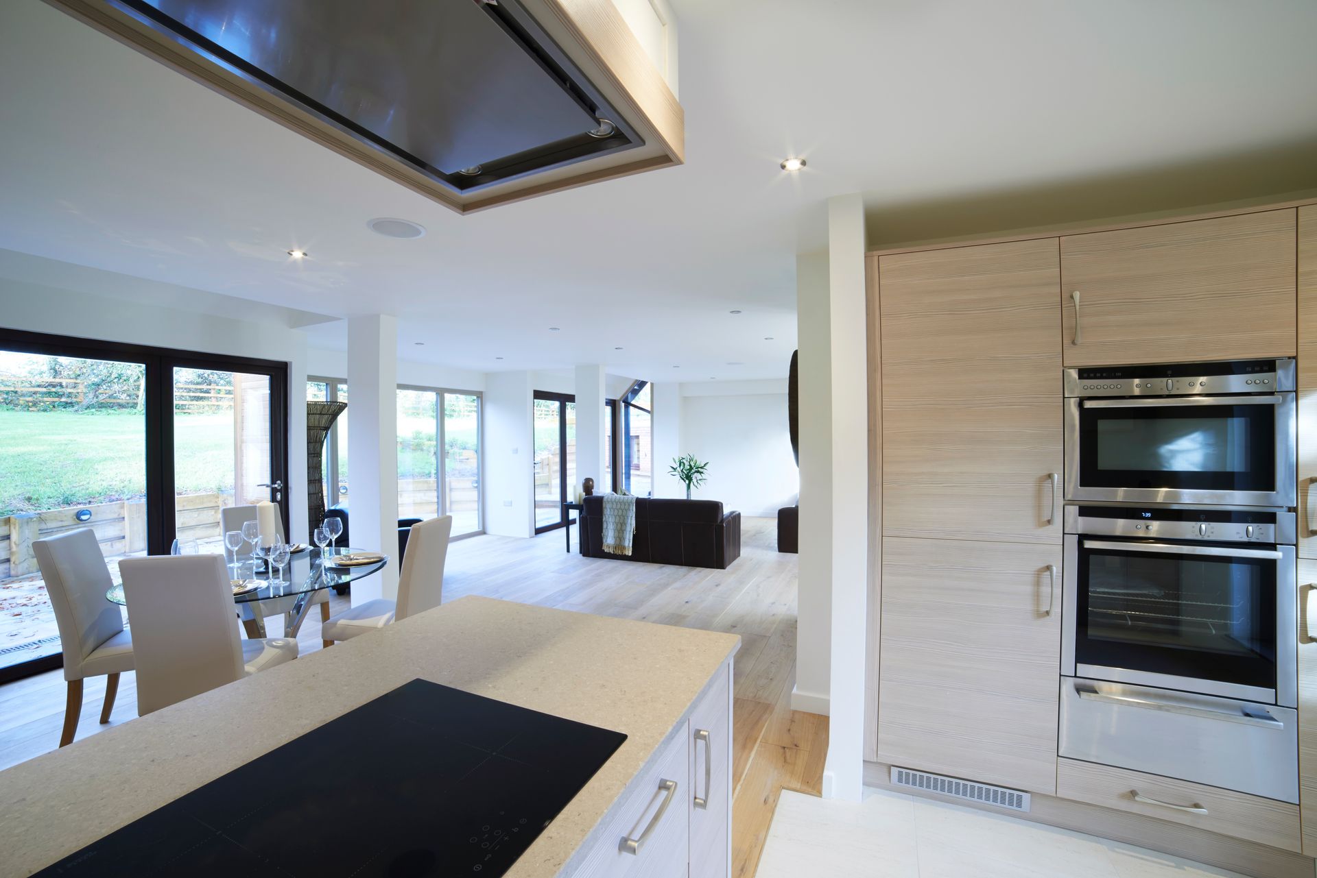 Cocina moderna con isla, electrodomésticos integrados y vistas abiertas al comedor y la sala de estar.