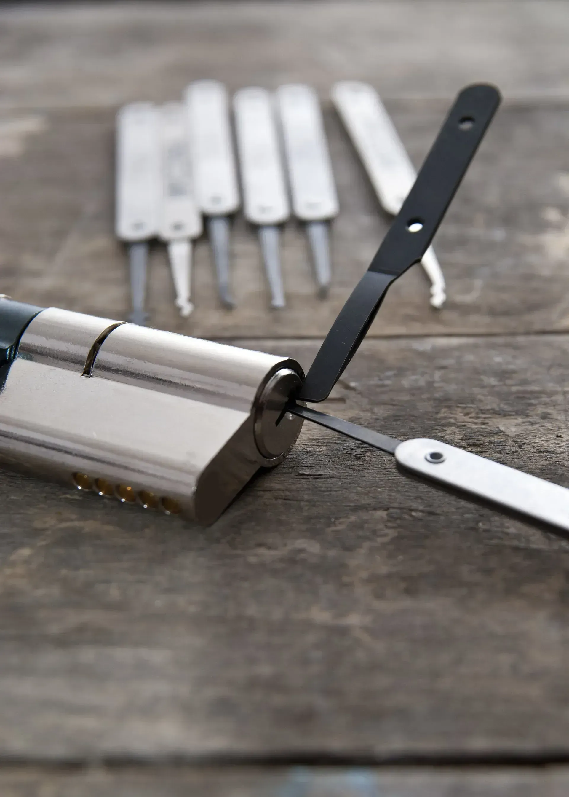 Crochetage d'une serrure à l'aide de crochets sur une surface en bois.