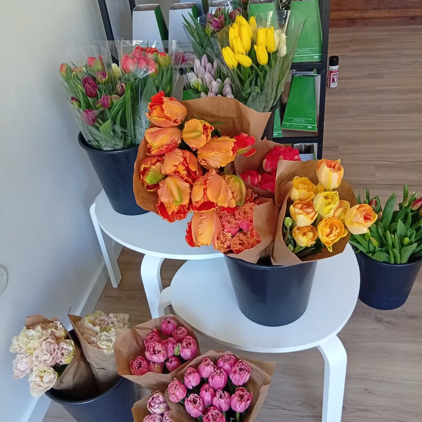 Bouquets de fleurs colorées disposés sur des tables dans un magasin ou sur un étal de marché.