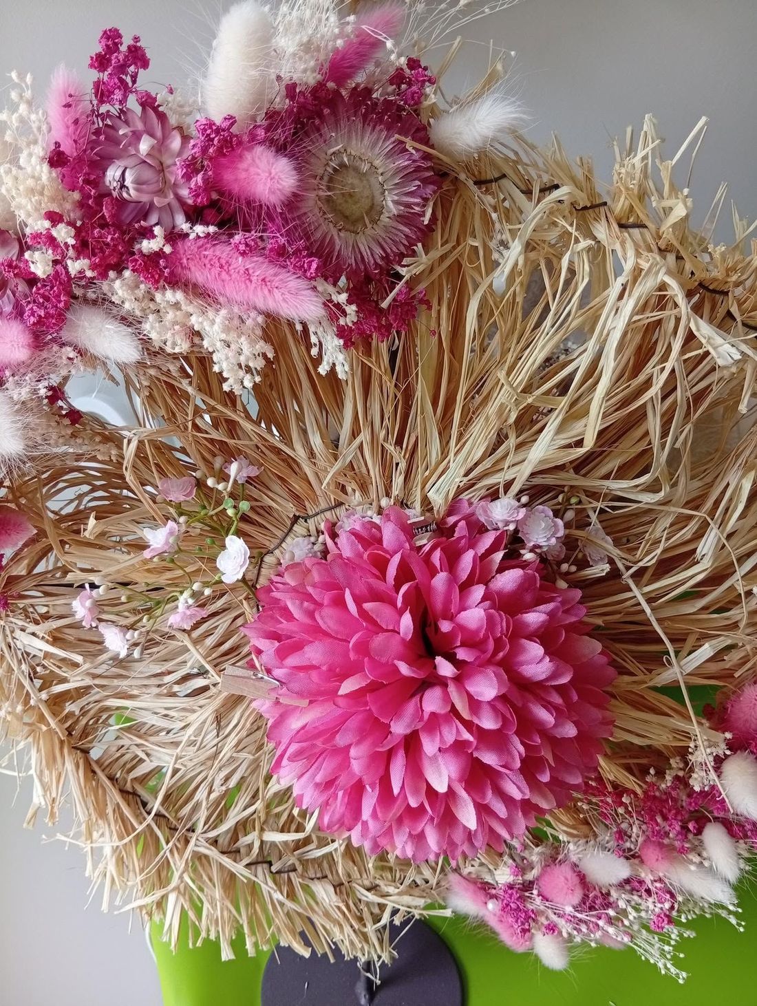 Couronne de fleurs séchées rose et beige à la texture pailleuse et aux fleurs magenta éclatantes