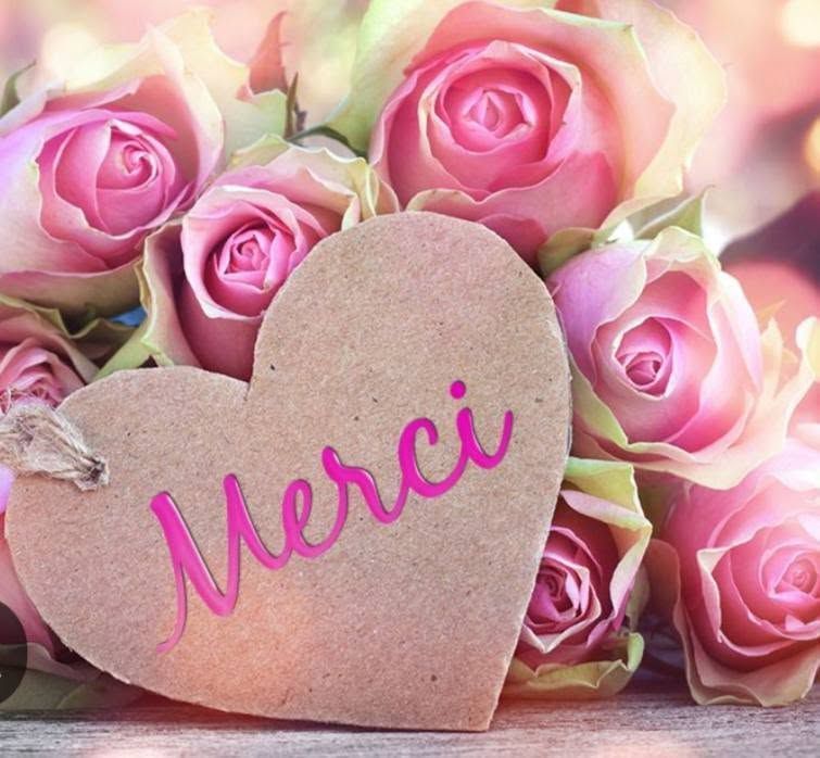 Des roses roses accompagnées d'une carte en forme de cœur portant l'inscription Merci.