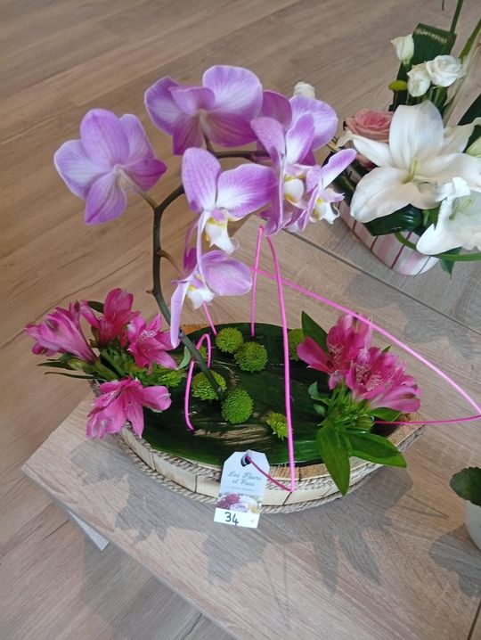 Composition florale d'orchidées colorées dans un panier décoratif sur une table en bois