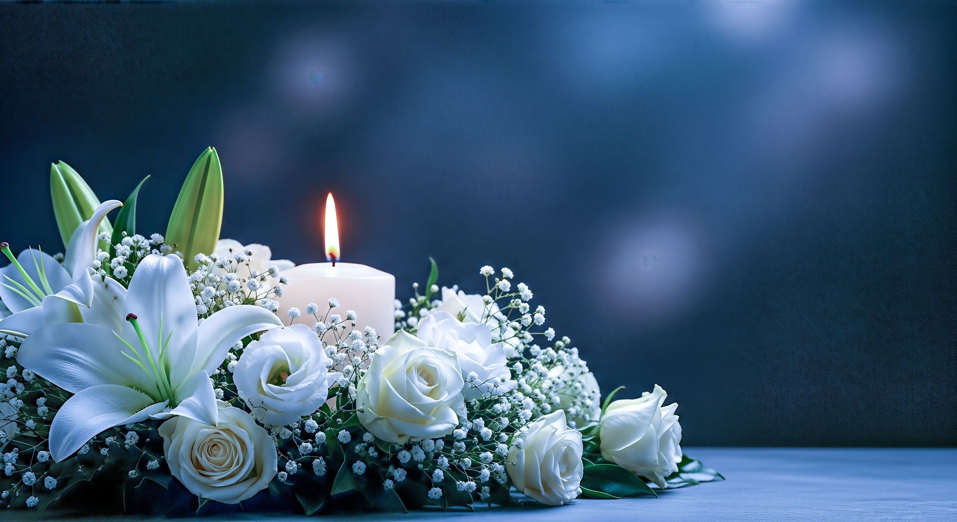 Des fleurs blanches et une bougie allumée disposées en un hommage serein sur une surface bleue.