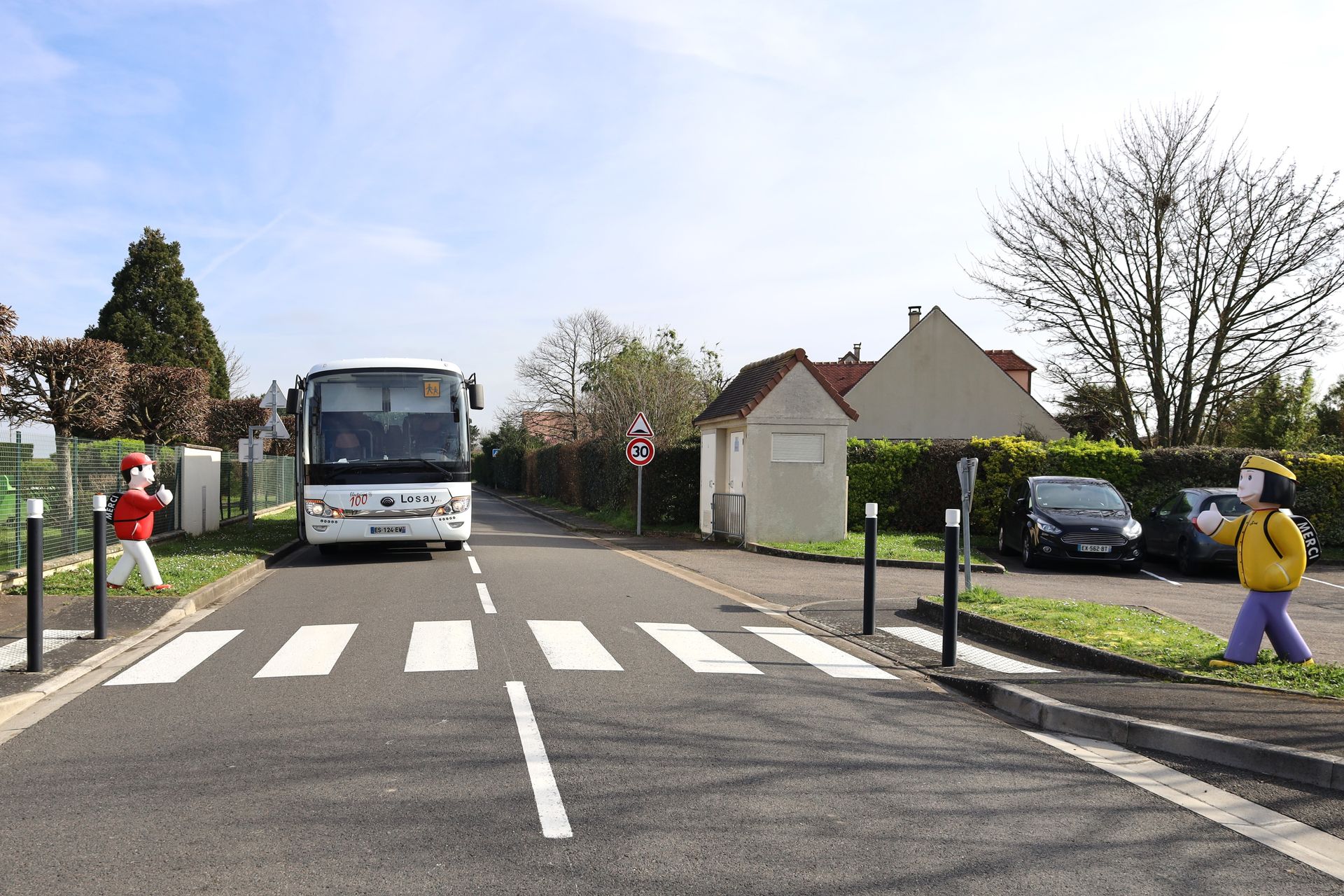 Autocar en ville qui circule avec un passage piéton