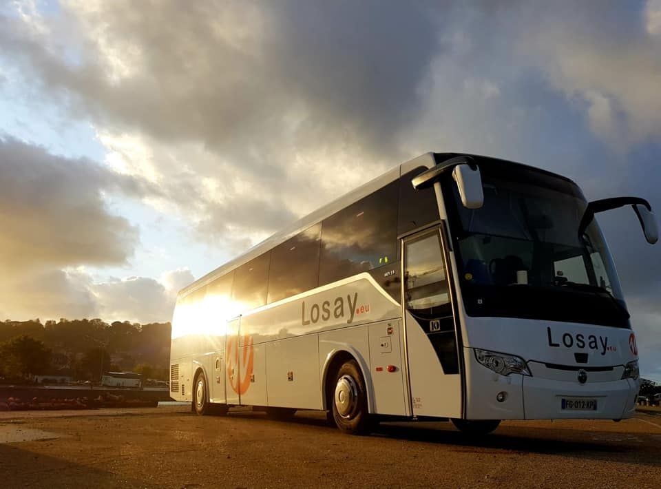 Autocar garé vu de devant avec coucher de soleil