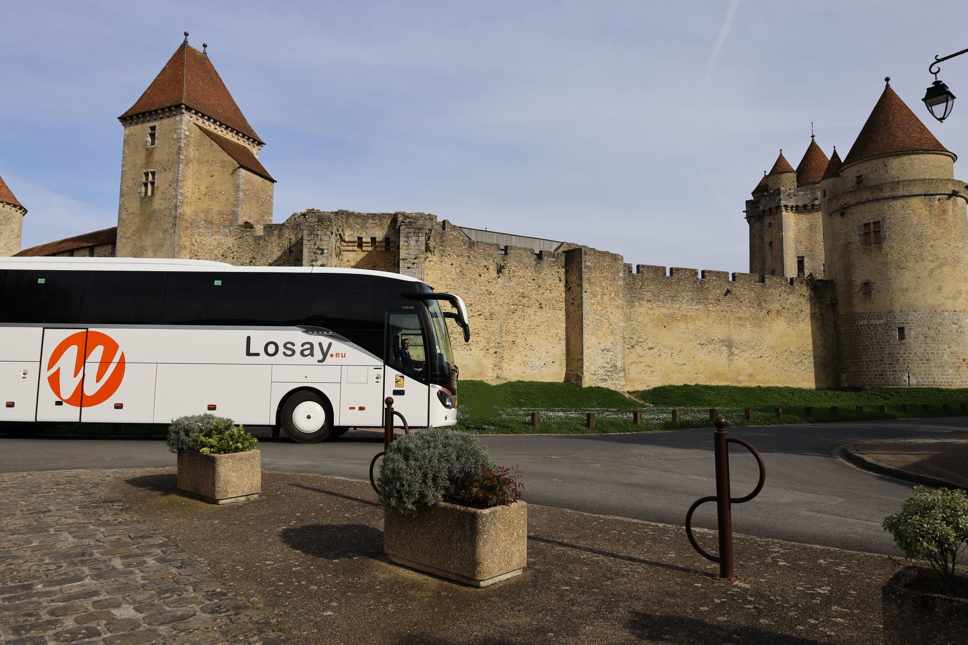 Autocar roulant autour d'un monument historique médiéval