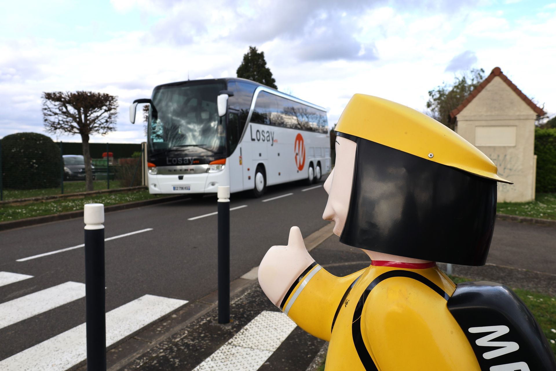 Bus Losay Voyages en fond et statue d'enfant au passage piéton