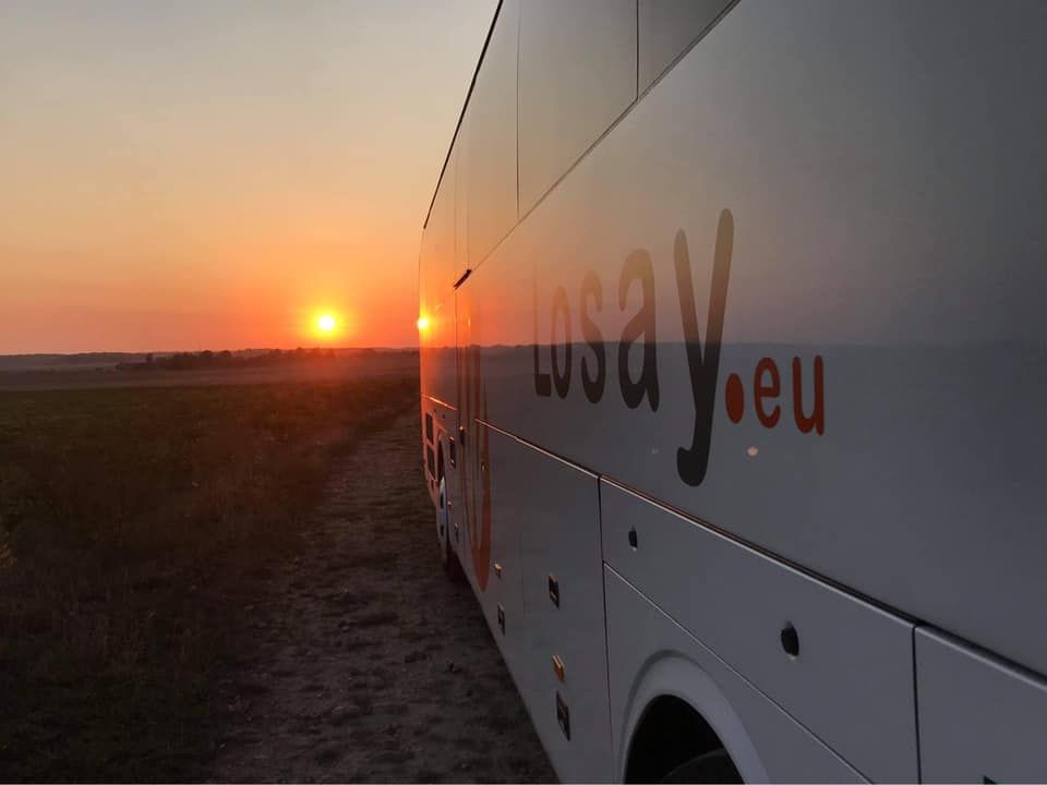 Vue sur le flanc d'un autocar Losay Voyages et coucher de soleil