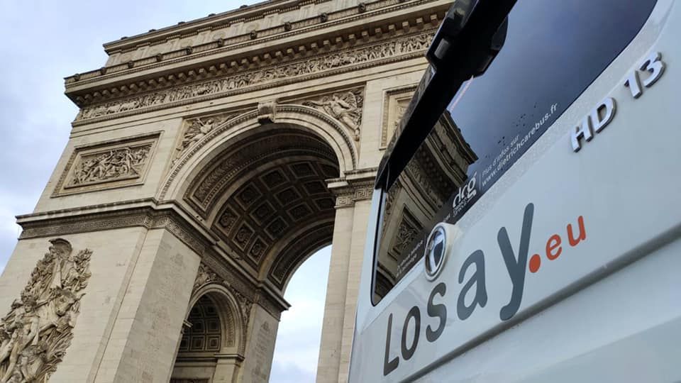 Vue sur l'Arc de Triomphe et l'arrière d'un autocar Losay Voyages