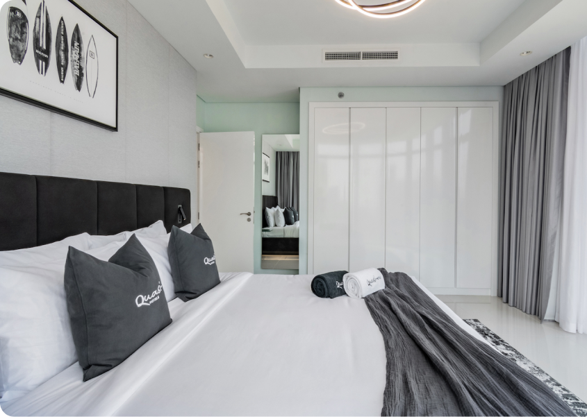 A bedroom with a large bed and a painting on the wall