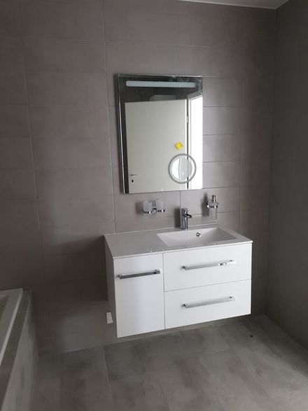 vue d'une salle de bain avec un lavabo, des tiroirs en dessous et un miroir au dessus