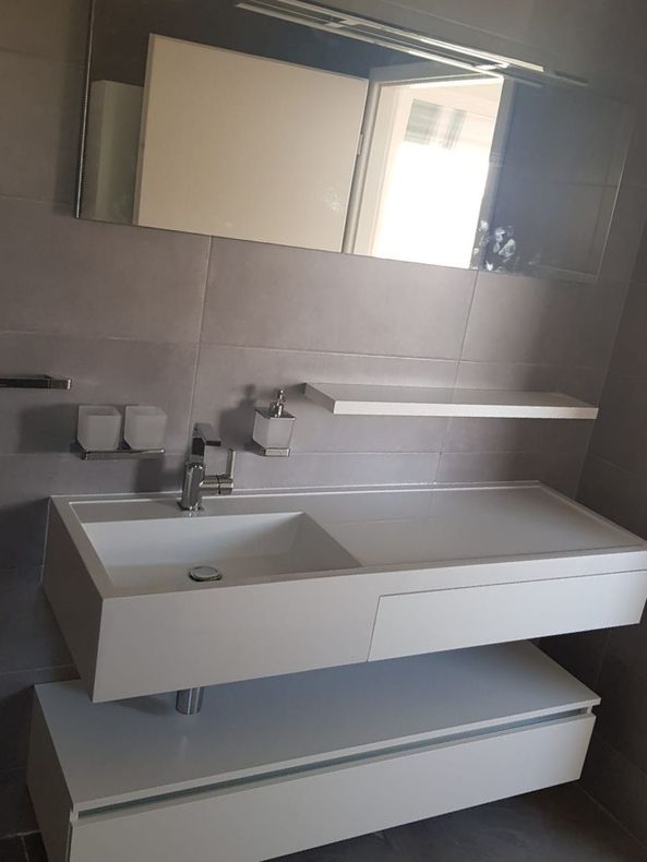 vue d'une salle de bain avec un lavabo, un meuble à tiroir en dessous et un miroir au dessus