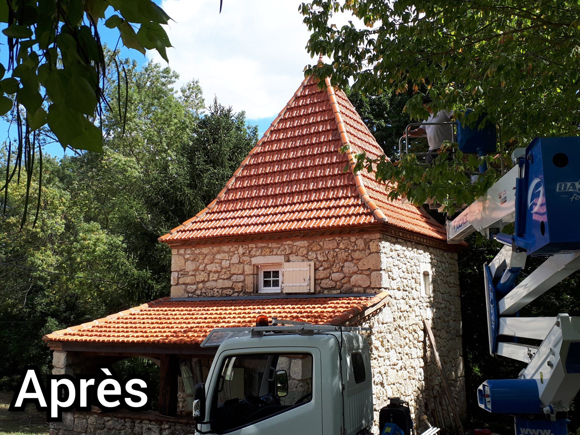 Démoussage d'une toiture très pentue à l'aide d'une nacelle pour un bâtiment en pierre, photo après travaux