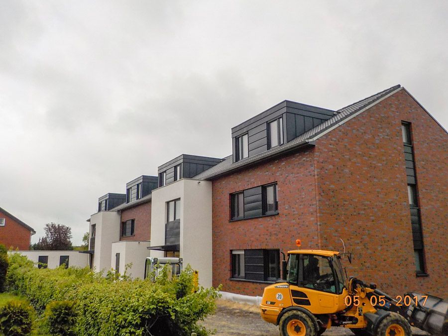 Ein gelber Bulldozer steht vor einem Backsteingebäude