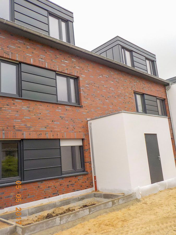 Ein Backsteingebäude mit vielen Fenstern und einer Tür.