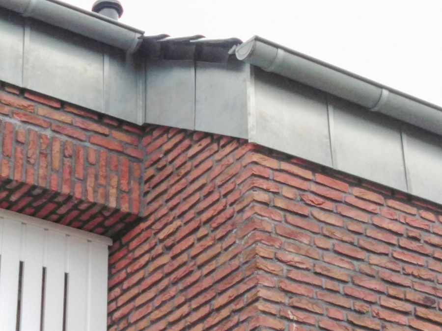 Ein Backsteingebäude mit einer Dachrinne an der Seite