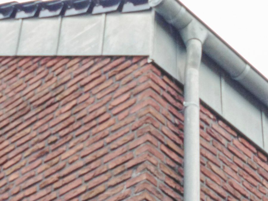 Ein Backsteingebäude mit einer Dachrinne an der Seite