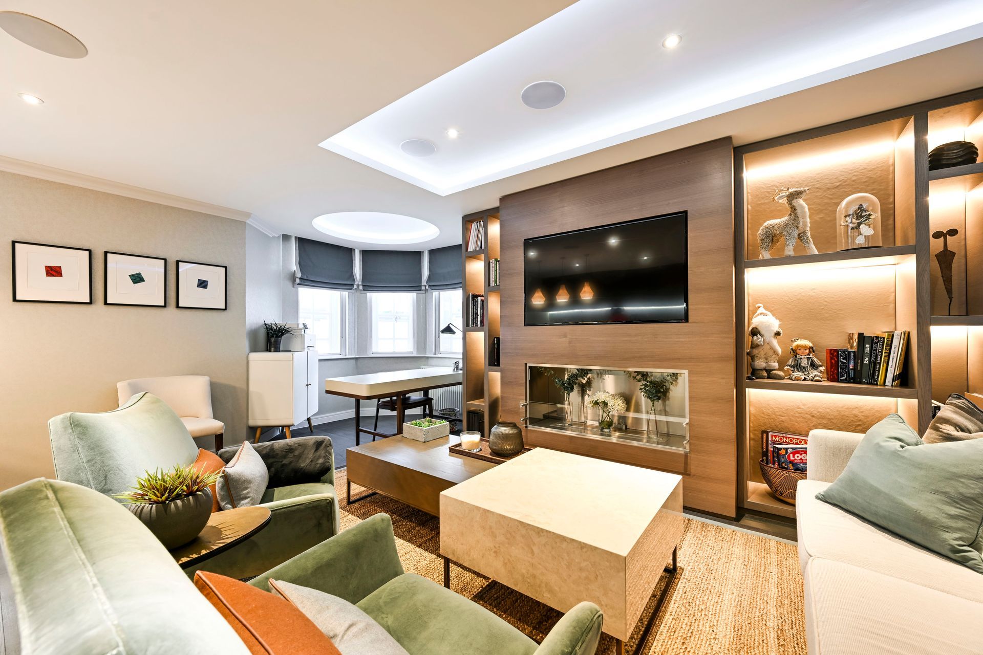 Modern living room with designer furniture, built-in shelving, wall-mounted TV, and dining area in a Central London apartment.