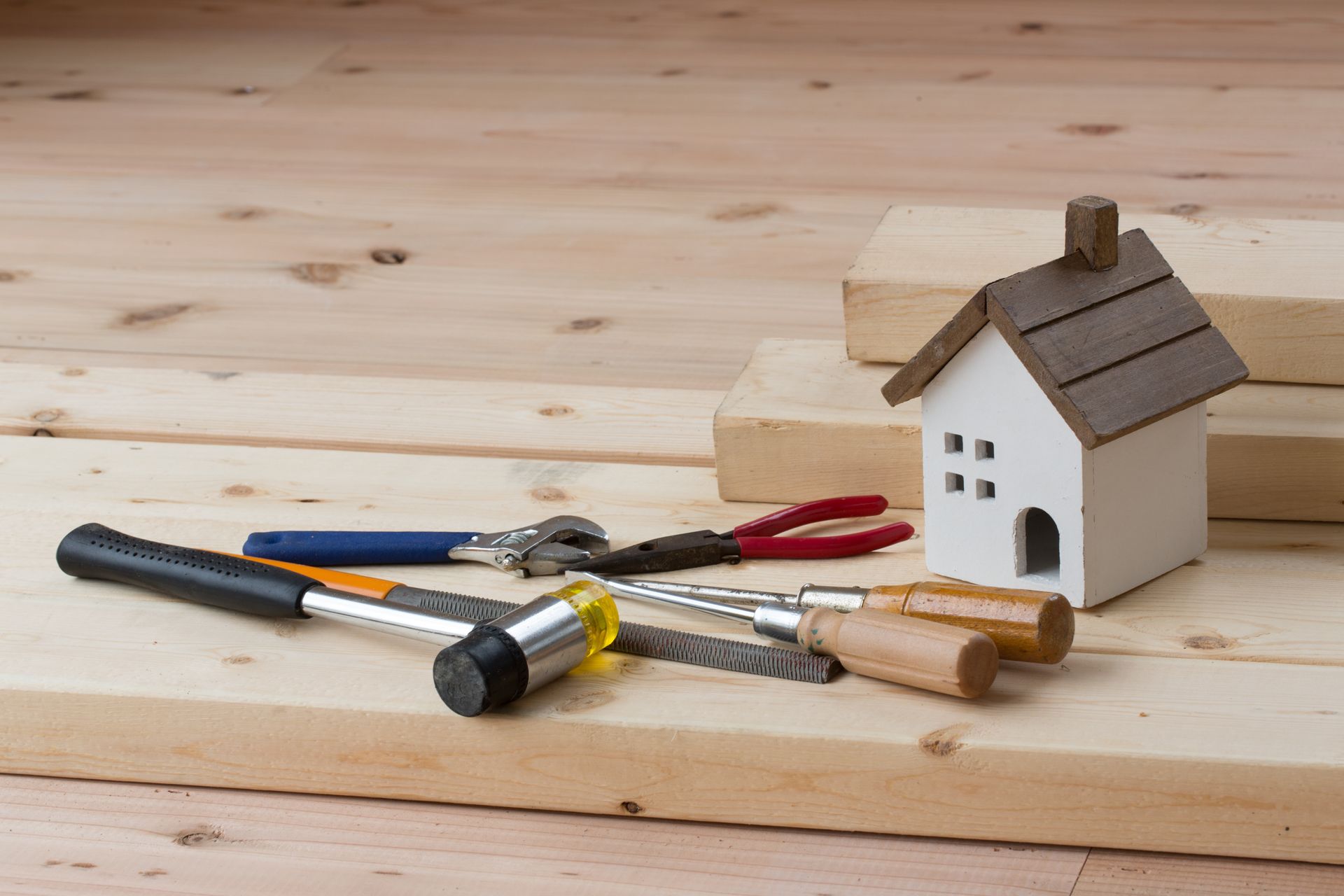 Un plancher avec des outils variés et une petite maison