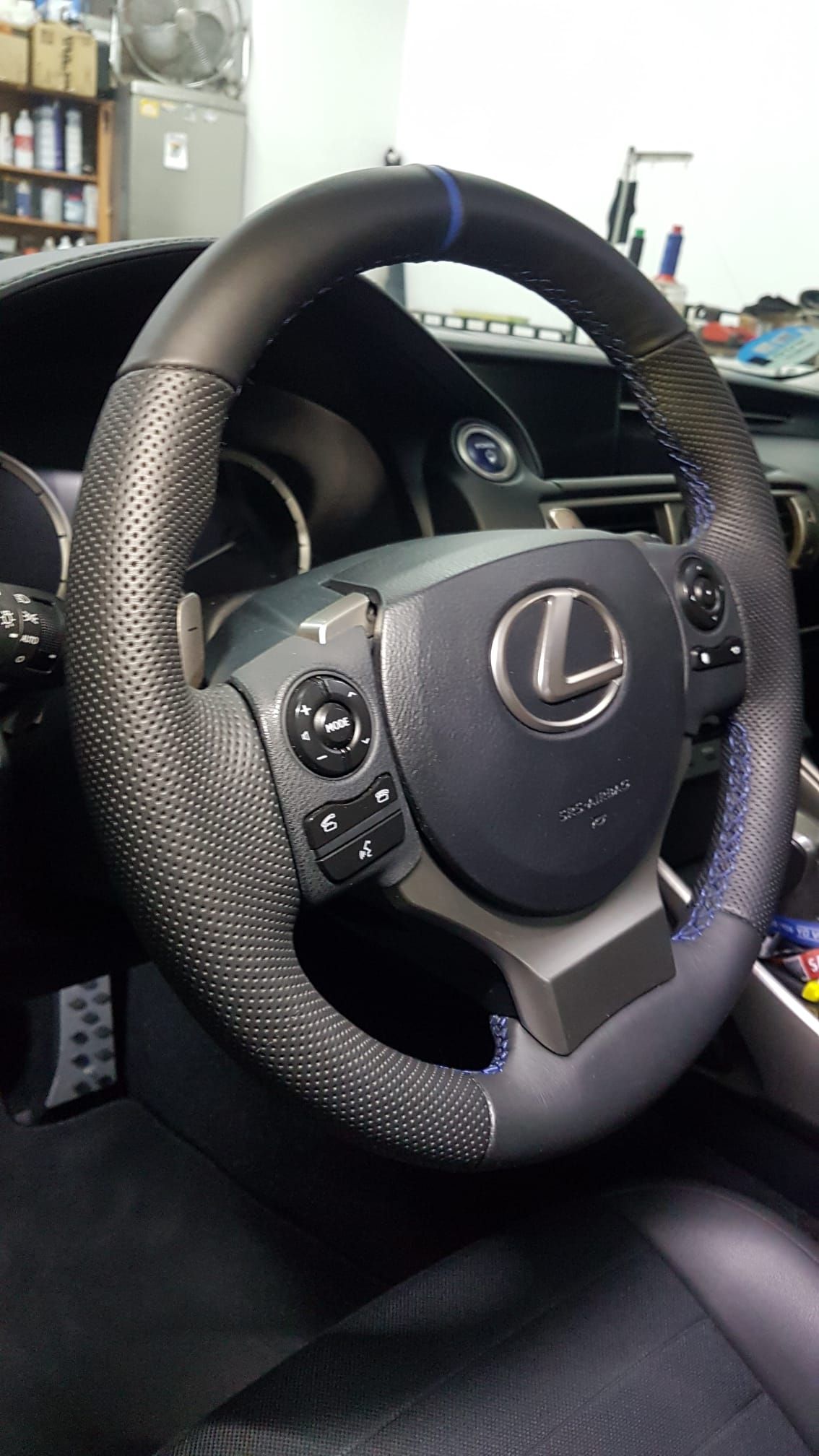 Primer plano de un volante Lexus con revestimiento texturizado en el interior de un automóvil.