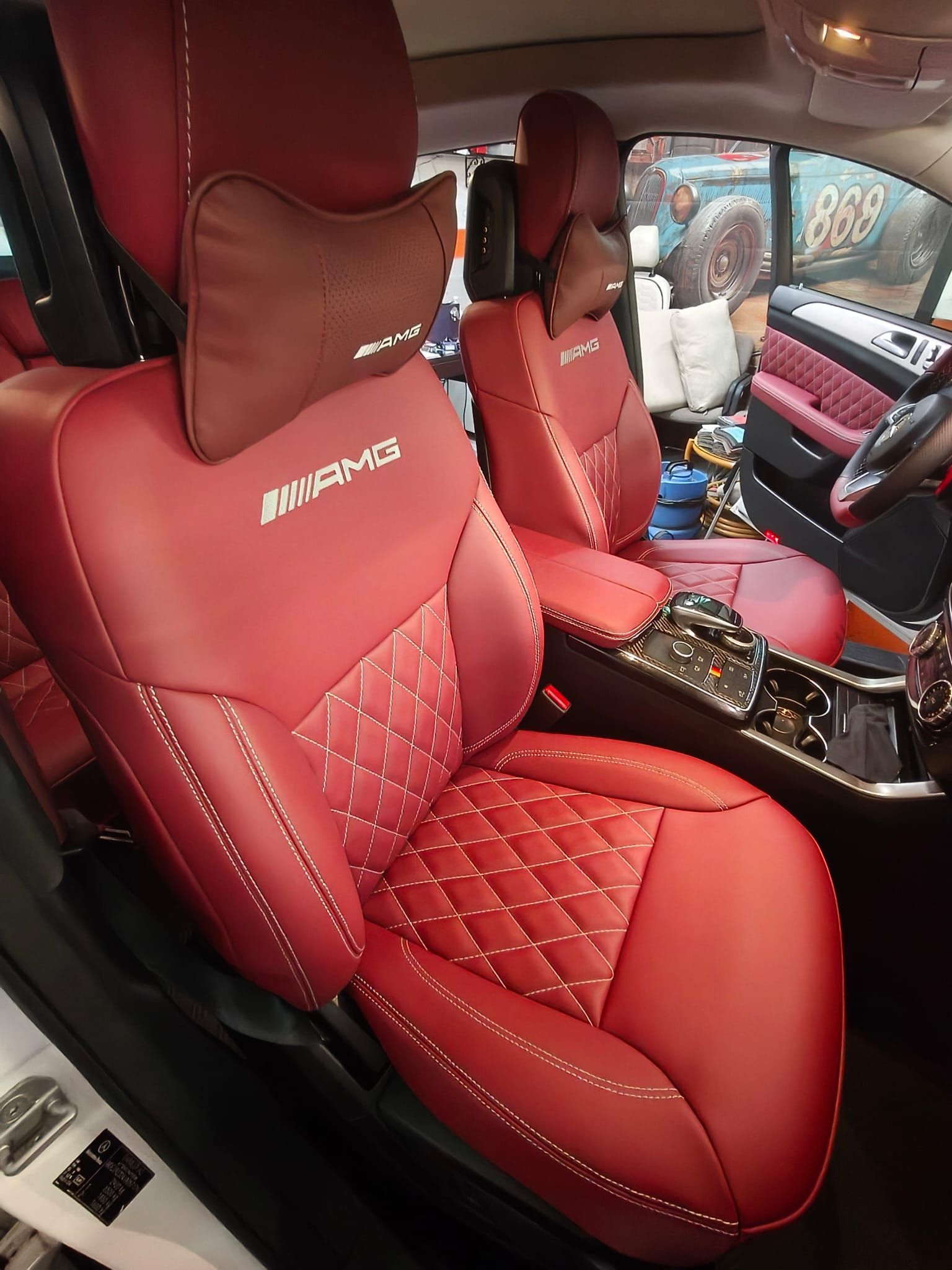 Interior del coche en cuero rojo y negro con costuras en forma de diamante y asientos de competición 
