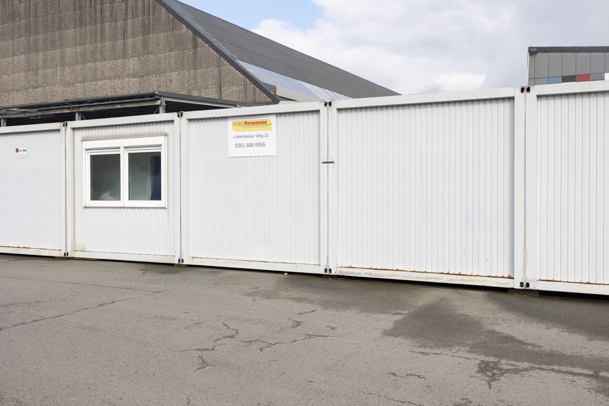 Ein weißer Zaun mit einem Schild mit der Aufschrift „Warnung“ darauf