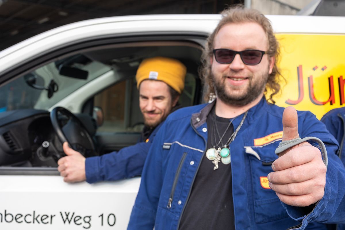 Zwei Männer zeigen vor einem Lieferwagen den Daumen nach oben