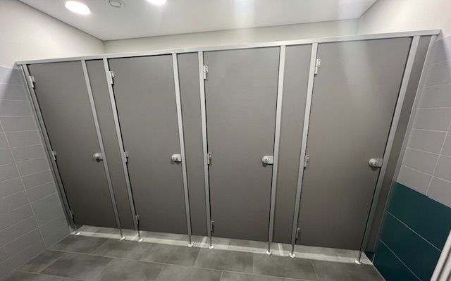 Eine Reihe von Toilettenkabinen in einer öffentlichen Toilette.