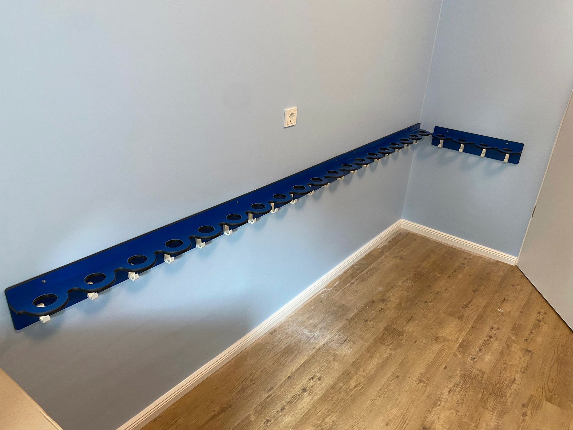 Eine blaue Wand mit einer Reihe von Haken daran