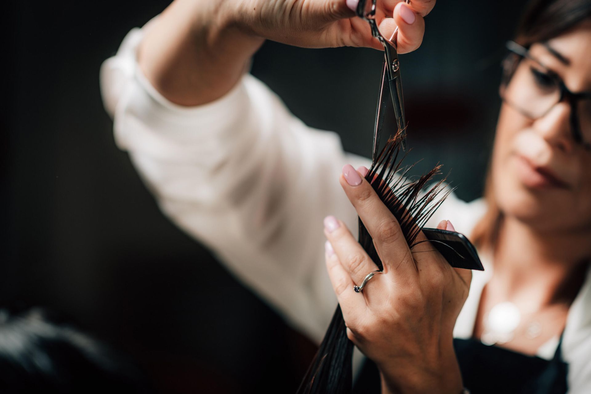Una mujer se corta el pelo con unas tijeras y un cepillo.