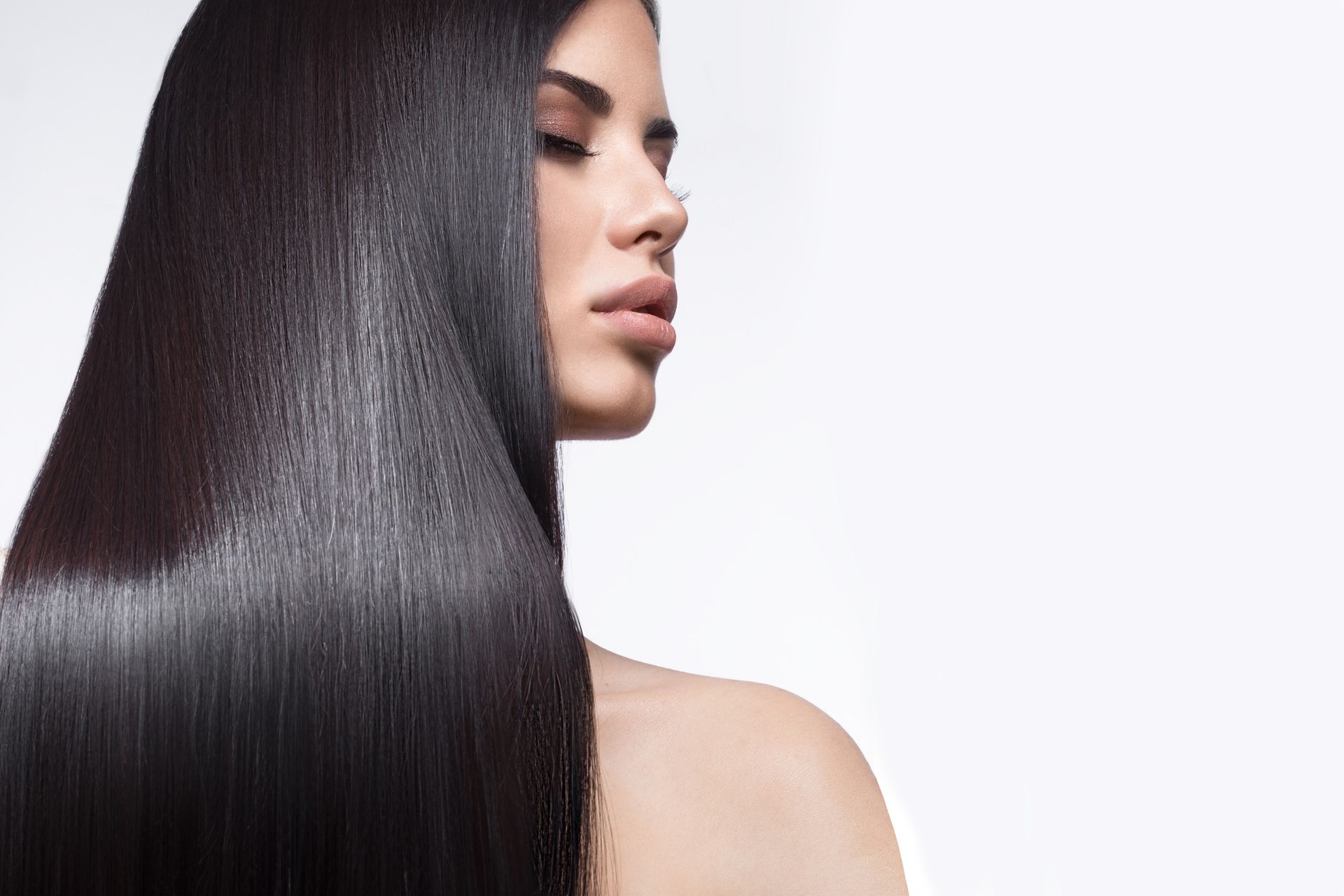 Una mujer con cabello largo y liso mira hacia abajo.