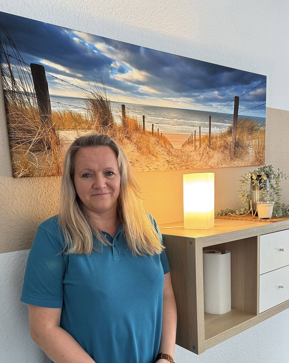 Eine Frau trägt eine weiße Jacke und ein schwarzes Oberteil.