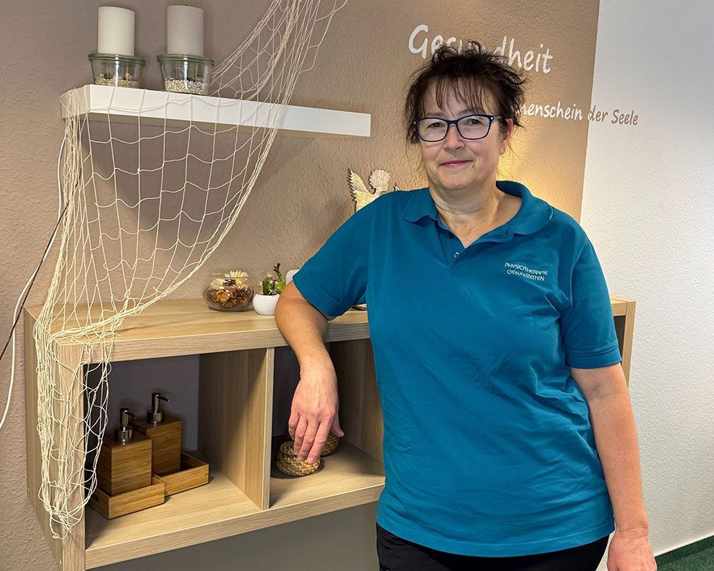 Eine Frau trägt eine weiße Jacke und ein schwarzes Oberteil.