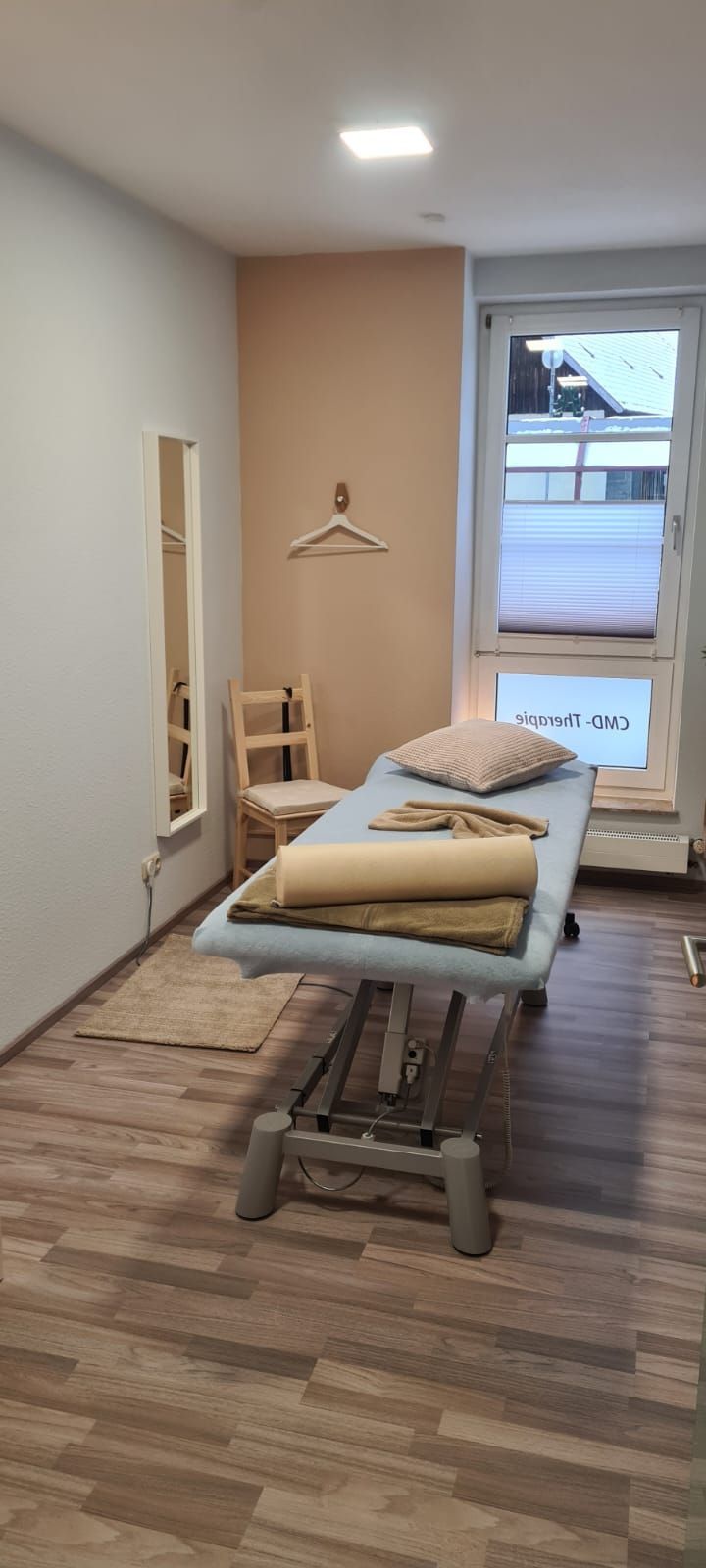 In der Mitte des Raumes steht eine Massageliege.