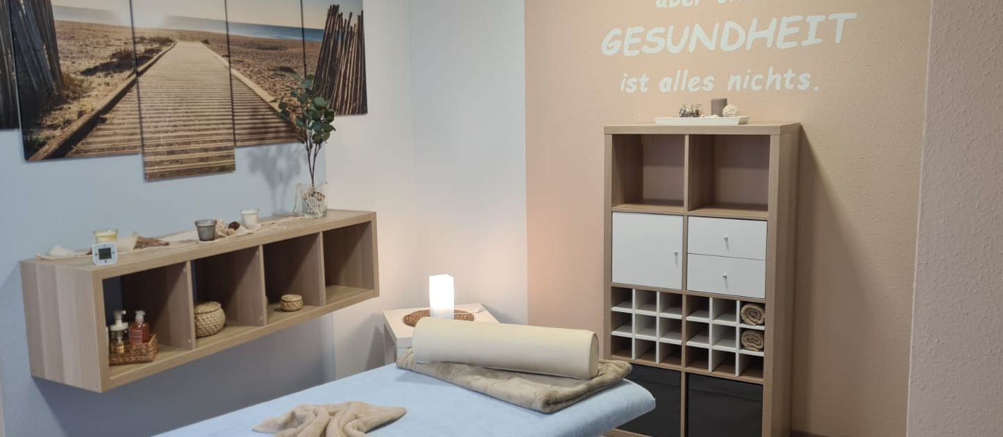 Eine Massageliege in einem Raum mit einem Schild an der Wand.