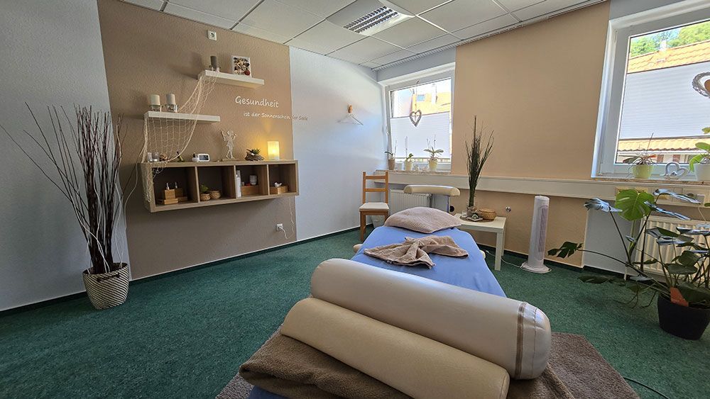 In der mitte des raumes steht eine massageliege.